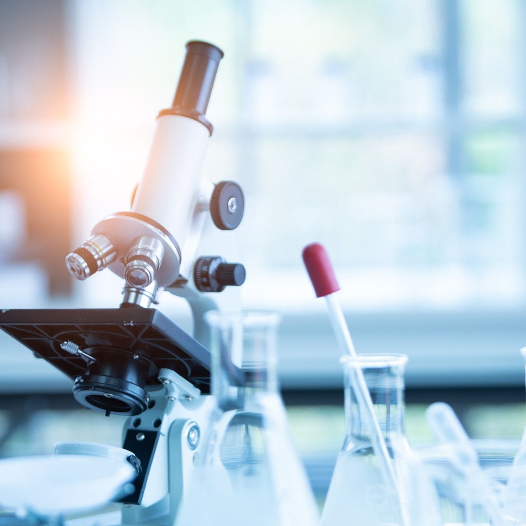 local lab a microscope placed on a table next to a glass tube